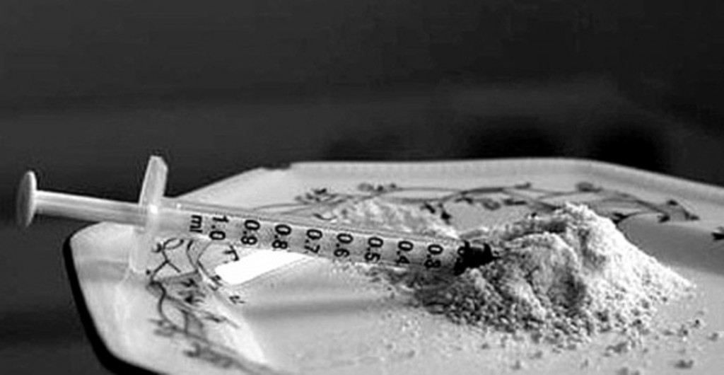 B&W shot of a syringe and drugs on a plate