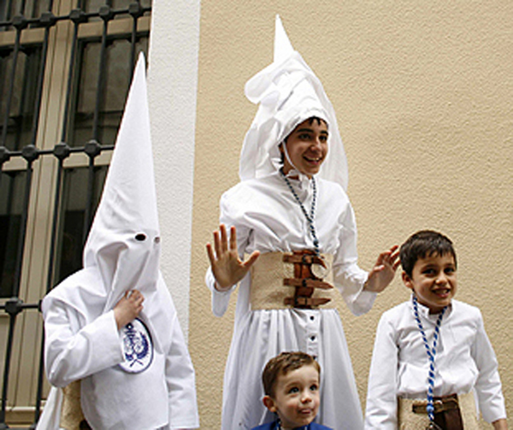 Young penitents wait before starting the procession of 'La Candelaria' brotherhood during Holy Week in the Andalusian capital of Seville