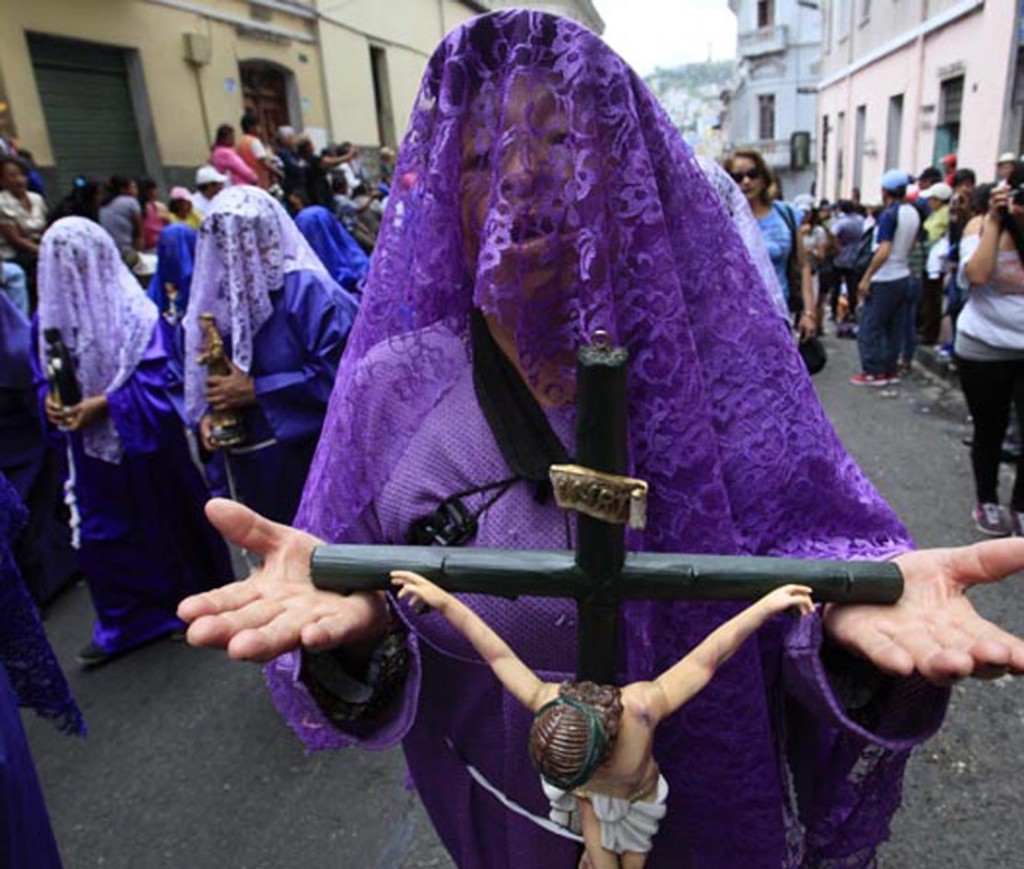 A veiled woman, recognized as a "Veronica," holds up a crucifix as she takes part in the Good Friday procession in Quito, Ecuador, March 29, 2013. Christians all over the world attend ceremonies that mark the day Jesus Christ was crucified, commonly known as Good Friday. Veronica is believed to be the women who wiped the face of Jesus, as he carried his cross, with a cloth upon which he left the imprint of his face. (AP Photo/Dolores Ochoa)
