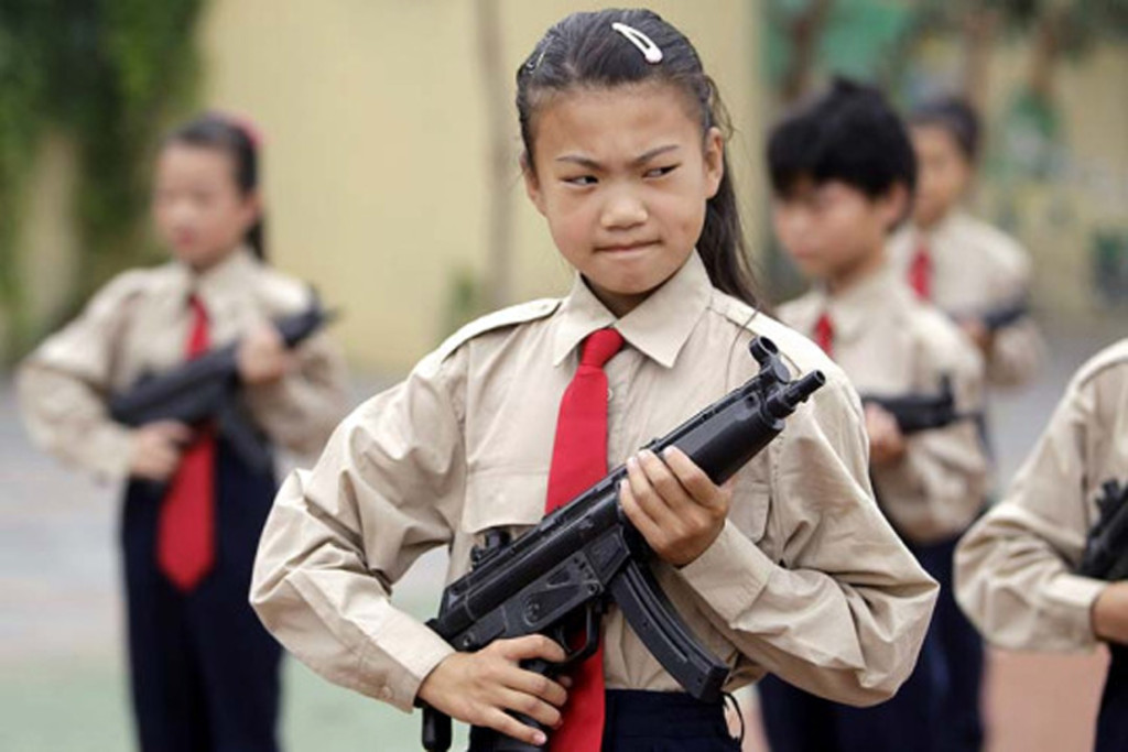 Students holding toy guns prepare for a parade for students visiting from Hong Kong at Jiangtaiwa primary school, a school for children of migrant labourers, in Beijing, August 24, 2010. REUTERS/Jason Lee (CHINA - Tags: EDUCATION IMAGES OF THE DAY SOCIETY)