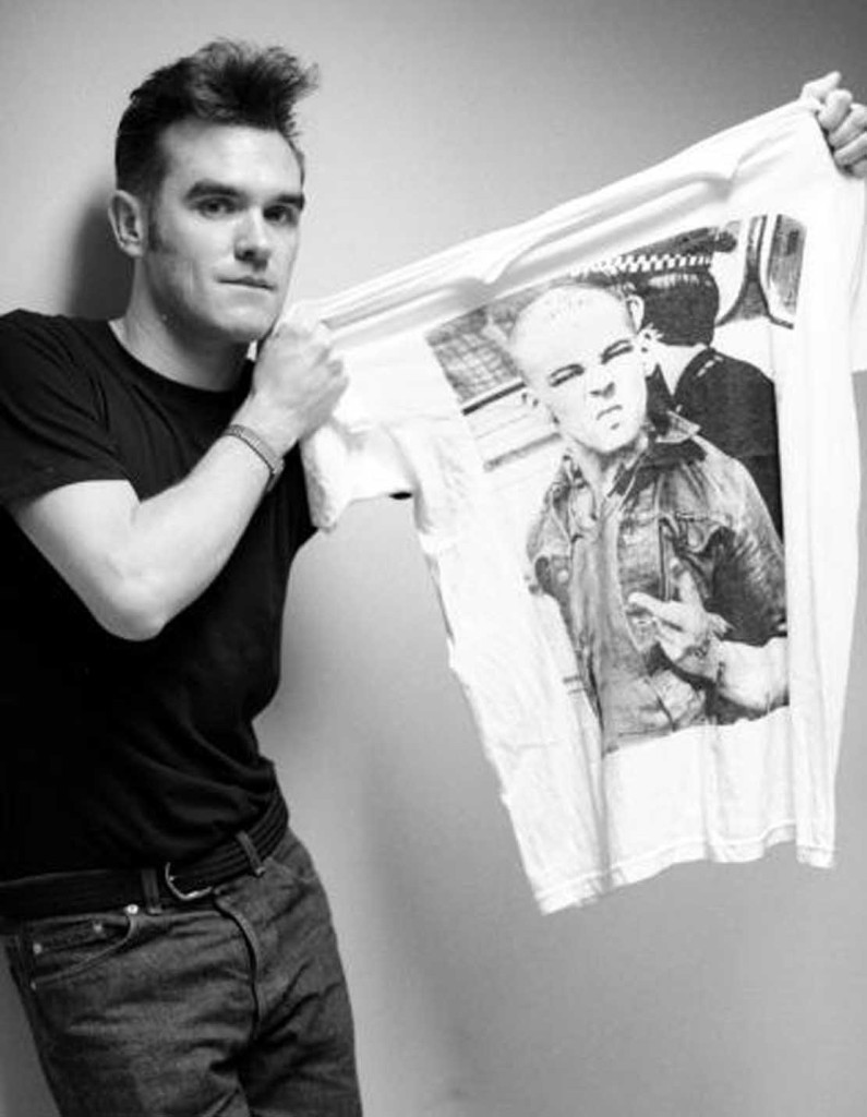 English singer and lyricist Morrissey, 5th September 1991. He is holding up a T-shirt featuring a photograph, by John Downing, of a skinhead being led away by a police officer in Southend, 7th April 1980. (Photo by Kevin Cummins/Getty Images)