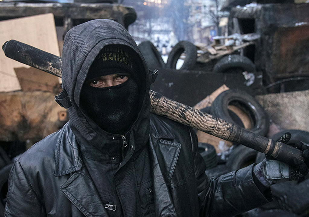An anti-government protester stands on barricades at the site of clashes with riot police in Kiev, January 31, 2014. Ukraine's embattled President Viktor Yanukovich on Friday signed into law an amnesty for demonstrators detained during mass unrest and repealed anti-protest legislation, in a fresh bid to take the heat out of the political crisis.