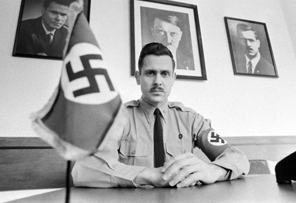 10 Feb 1972, Arlington, Virginia, USA --- Commander of the National Socialist White People's Party, Matt Koehl is seated at his desk, complete with a swastika flag, at the headquarters of the party. On the wall are pictures of George Lincoln Rockwell, leader of the American Nazi party, Adolf Hitler, and himself as the present commander. --- Image by © JP Laffont/Sygma/Corbis