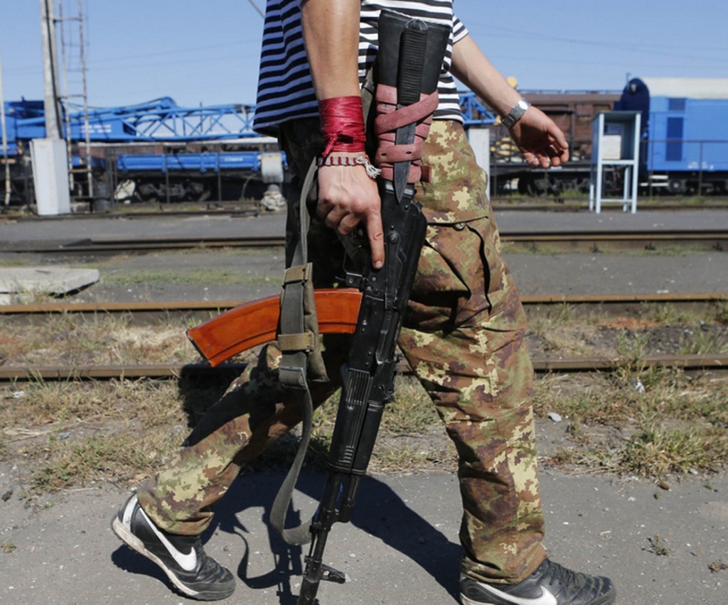 A pro-Russian separatist walks along a railroad station in the eastern Ukrainian town of Ilovaysk