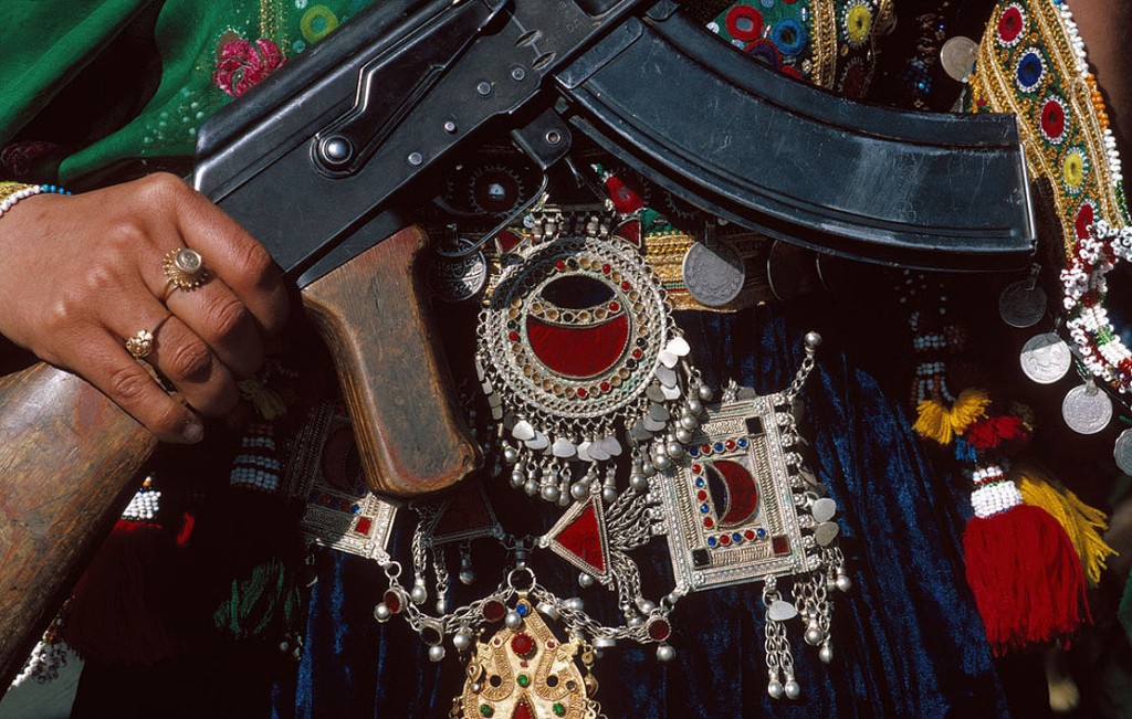 AFGHANISTAN. Kabul. May 27, 1986. A Muslim woman in traditional clothes and jewellery celebrates the anniversary of the Coup d'Etat of 1978 when Communists seized power. She holds a Russian-made Kalashnikov submachine gun.